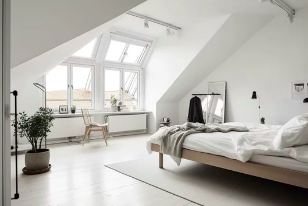 Bright white loft bedroom with Juliet balcony