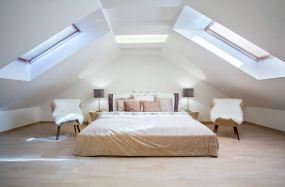 Loft master bedroom lit by roof windows